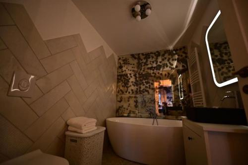 a bathroom with a tub and a sink and a toilet at The Oracle Downtown Apartment in Sibiu