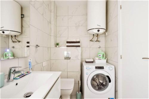 y baño con lavadora y lavamanos. en PaulMarie Family Apartment Ocean&Mountain View en Adeje
