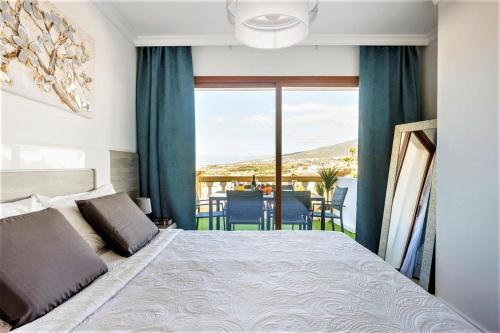 1 dormitorio con cama y vistas a una mesa en PaulMarie Family Apartment Ocean&Mountain View, en Adeje
