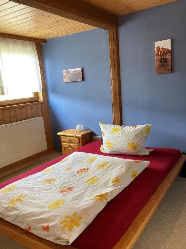 a bed in a bedroom with a blue wall at Ferienwohnung Schwabenhof in Leutershausen