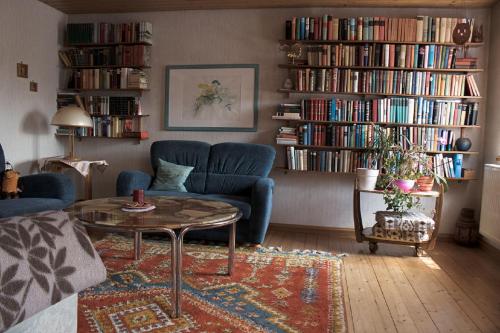 sala de estar con sofá, mesa y libros en Ferienwohnung Schwabenhof en Leutershausen