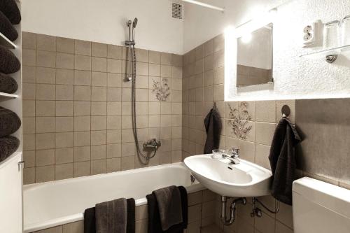 ein Badezimmer mit einem Waschbecken, einer Badewanne und einem Waschbecken in der Unterkunft Arkadia - Ferienwohnung - Uhlandweg in Buckhorn