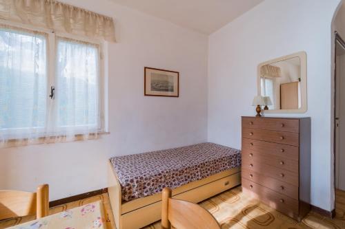 een slaapkamer met een bed, een dressoir en een raam bij Appartamenti Campo al Pero - Goelba in Casa Leonardi