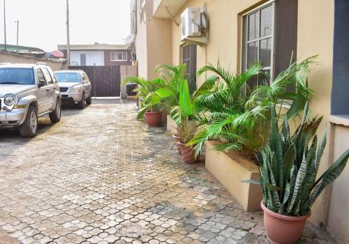 uma fila de vasos de plantas ao lado de um edifício em ARO APARTMENTS: (College Road) em Lagos