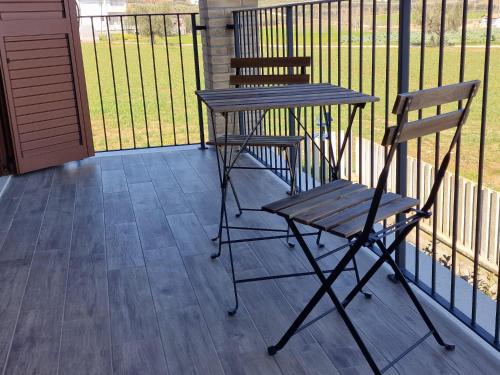 two chairs and a table on a porch with a fence at Casale Ferrantino in Giulianova
