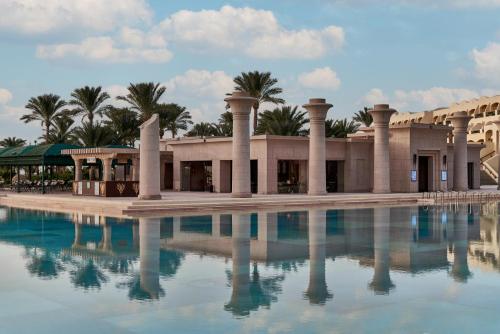 a building with a pool of water in front of it at Mosaique Beach Resort Taba Heights in Taba