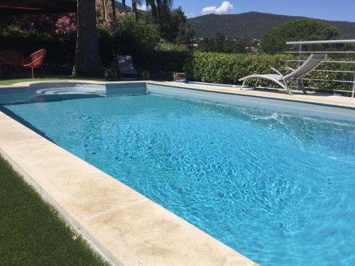 une piscine avec de l'eau bleue dans une cour dans l'établissement La vigie, à Cavalaire-sur-Mer