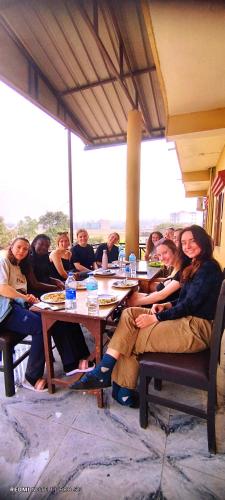 a group of people sitting at tables in a restaurant at Hotel National Park- A peaceful Family home where you can stay Peace and Enjoy and Organize the wildlife Safari in Chitwan