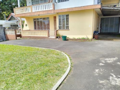 a house with a driveway in front of it at Leiko Guest House in Vacoas