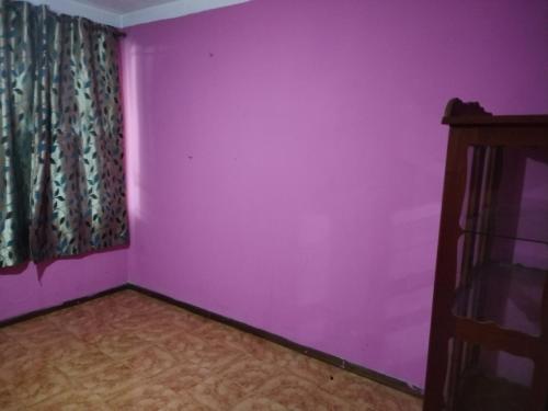 a room with a purple wall and a window at Leiko Guest House in Vacoas