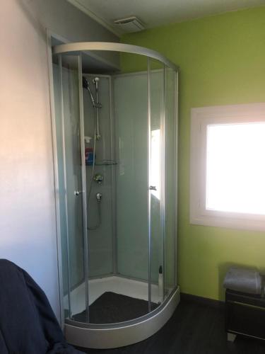 - une douche en verre dans une pièce verte avec une fenêtre dans l'établissement Chambres climatisées en Sologne pour 1 à 4 Hôtes, à Nouan-le-Fuzelier