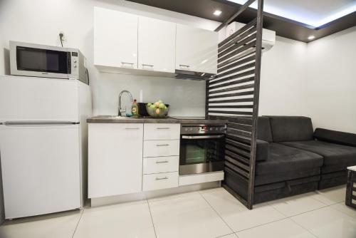 eine Küche mit weißen Schränken und einer Couch darin in der Unterkunft Villa San Antonio-exclusive apartments in Baška
