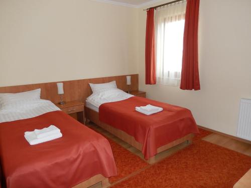 a hotel room with two beds and a window at Frittmann Borház in Soltvadkert