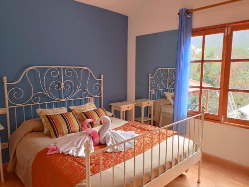 Un dormitorio con una cama con dos muñecas. en Chalet Juana La Concha Valle de Agaete, en San Pedro