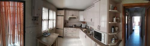 una cocina con armarios blancos y fregadero en Room in Guest room - Double Room in Chalet in Toledo, en Toledo
