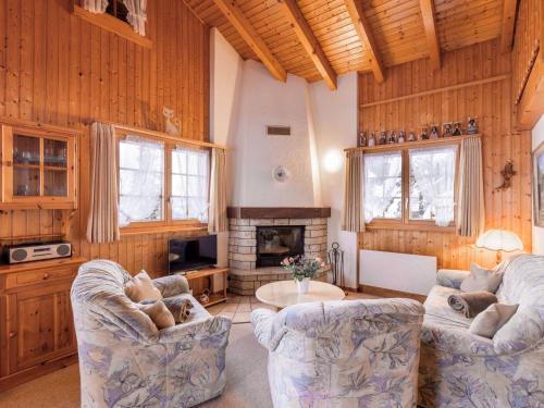 a living room with two chairs and a fireplace at Chalet Eloise by Interhome in Nendaz