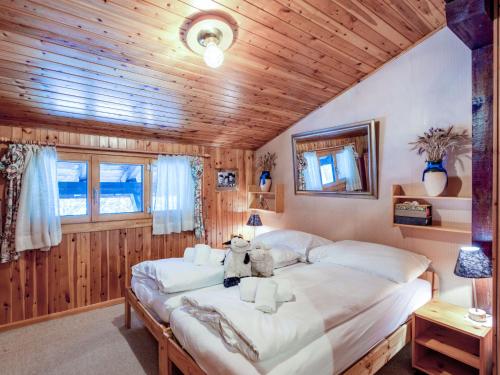a bedroom with a large bed in a room with wooden walls at Apartment Chaedoz 65 by Interhome in Nendaz