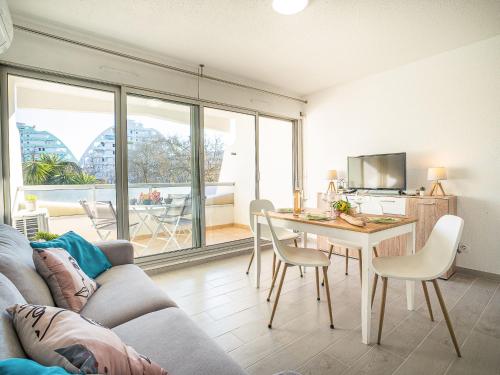 un salon avec un canapé et une table avec des chaises dans l'établissement Studio du Parc I-4 by Interhome, à La Grande Motte