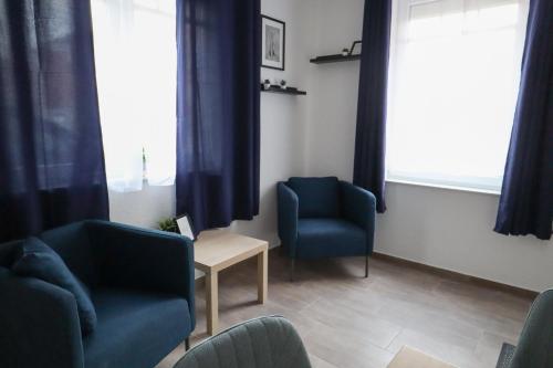 a waiting room with two chairs and a table at Apartments am Lindengraben in Emden