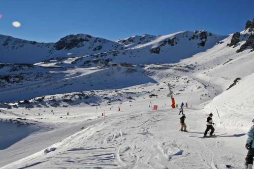 a group of people skiing down a snow covered mountain at Las Caldas de Boñar Casa alquiler completo in Boñar