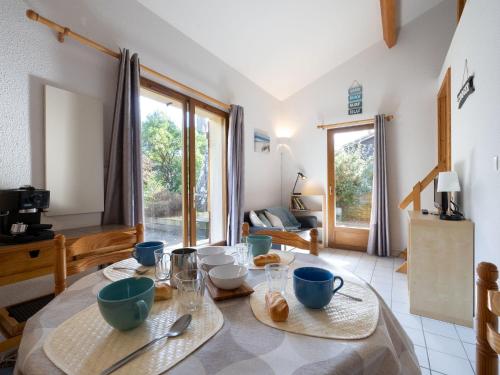 d'une salle à manger avec une table et des plats bleus. dans l'établissement Holiday Home Jardins de la Pinède-9 by Interhome, à Lacanau-Océan