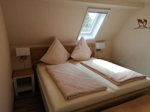 a bedroom with a bed with pillows and a window at May Home in Schashagen