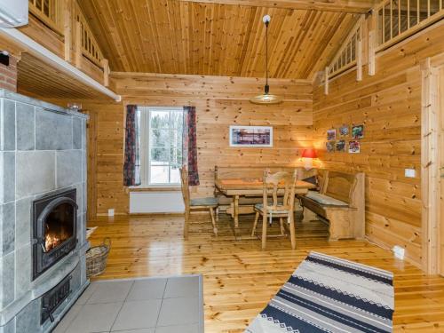 a log cabin living room with a table and a fireplace at Holiday Home Pihlajapelto by Interhome in Ahmovaara
