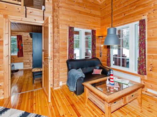 a living room with a couch and a table at Holiday Home Pihlajapelto by Interhome in Ahmovaara
