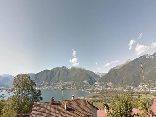 a view of a city and a lake with mountains at Apartment Bella Vista - EG by Interhome in Magadino
