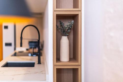 a white vase with flowers on a shelf in a kitchen at NR Urban Torre 2 in Santa Cruz de Tenerife