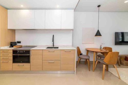 a kitchen with white cabinets and a table with chairs at NR Urban Torre 2 in Santa Cruz de Tenerife