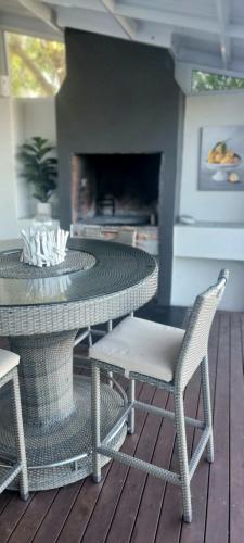 a patio with a table and chairs and a fireplace at Emmaus-On-Sea in Yzerfontein