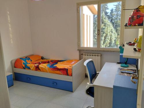 a small bedroom with a bed and a desk at Da Maurizio e Luisa in Castiadas