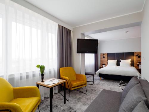 a hotel room with a bed and a tv at Mercure Czestochowa Centrum in Częstochowa