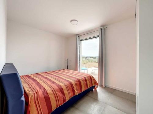 波爾蒂喬的住宿－Appartement Agosta，一间卧室设有一张床和一个大窗户