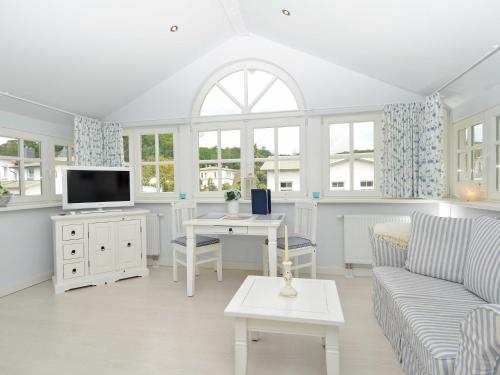 a living room with a couch and a tv at Villa "To Hus" in Sellin - Appartement 06 im DG mit Balkon in Ostseebad Sellin