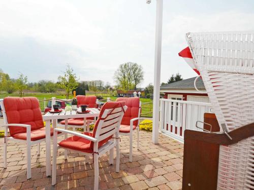eine Terrasse mit einem Tisch, Stühlen und einem Grill in der Unterkunft Villa "To Hus" F590 - Appartement 01 im EG mit Kamin und Terrasse in Ostseebad Sellin