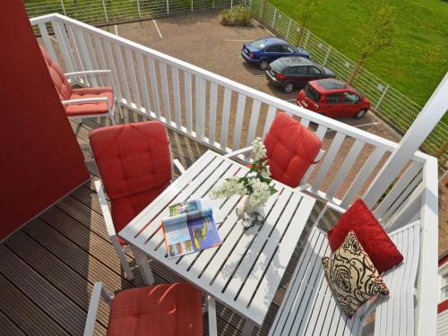 a balcony with a table and chairs and a car at Villa "To Hus" in Sellin - WG 02 mit Kamin und Balkon in Ostseebad Sellin