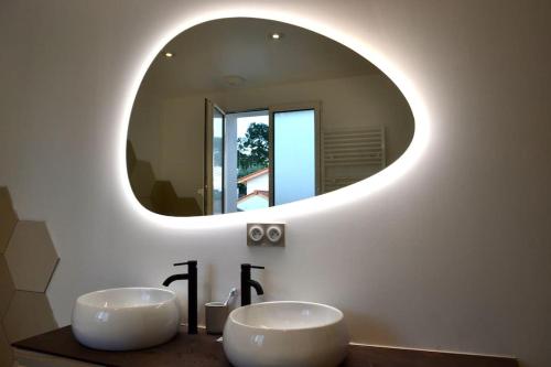 une salle de bain avec deux lavabos et un grand miroir dans l'établissement Maison moderne, près des plages et de la forêt., à Anglet