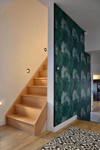 - un escalier dans une pièce dotée d'un mur vert dans l'établissement Maison moderne, près des plages et de la forêt., à Anglet