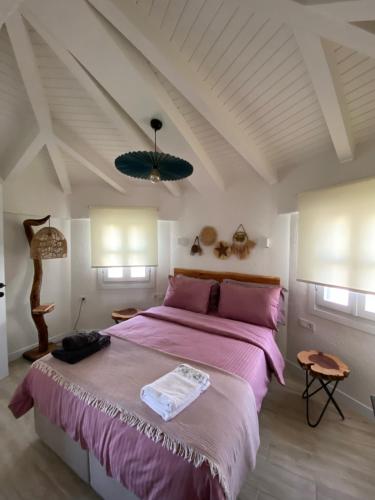 a bedroom with a large bed with pink sheets at La Maison de Yasmine in Alaçatı