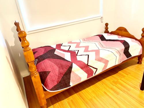 a bed with a quilt on it in a room at Fully Private 3 bedroom house with free parking in Fairfield