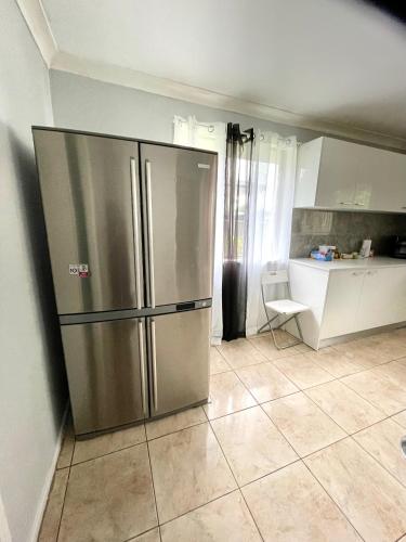 a kitchen with a large stainless steel refrigerator at Fully Private 3 bedroom house with free parking in Fairfield
