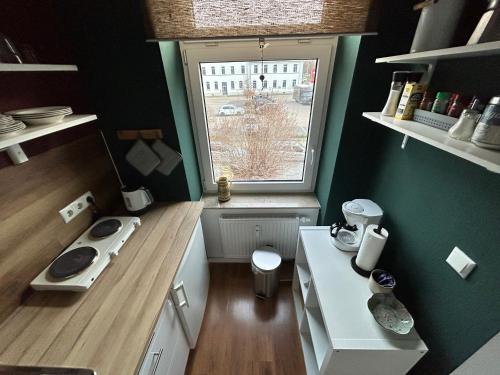 eine kleine Küche mit einer Theke und einem Fenster in der Unterkunft Buntes Haus in Erfurt