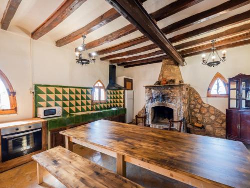 cocina con mesa de madera y chimenea en Holiday Home Mas d'en Tarres by Interhome, en Vespellà