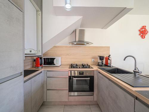 une cuisine avec un évier et une cuisinière dans l'établissement Apartment Les Galiotes-3 by Interhome, à Carnac
