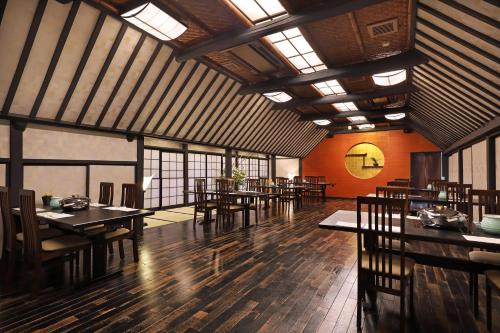a dining room with tables and chairs and windows at Hakone Kowakien Tenyu in Hakone