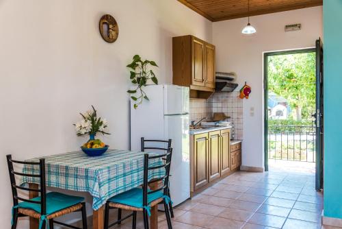 a kitchen with a table with chairs and a refrigerator at Nemorosa Holiday Houses in Méson Yerakaríon