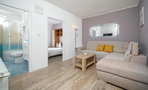 ein Wohnzimmer mit einem Sofa und einem Spiegel in der Unterkunft Apartmani Gabriella in Vodice