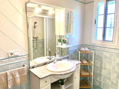 uma casa de banho branca com um lavatório e um espelho em Villa Fernando By Solymar Holiday em Málaga